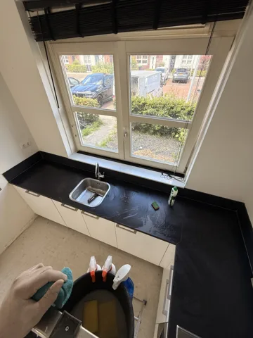 Reinigingswerk bij een keukenraam